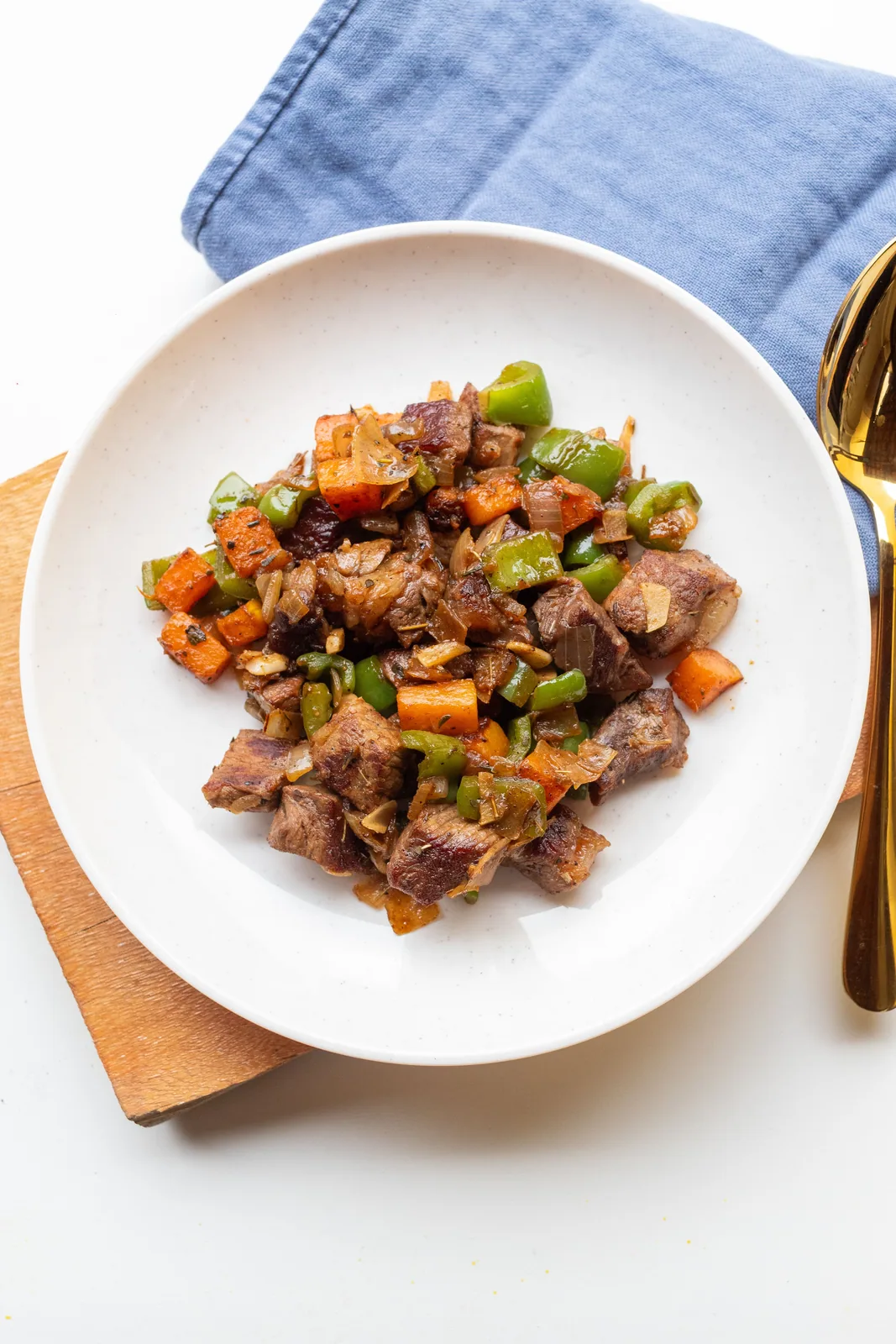 Cubed beef with vegetables on a white plate