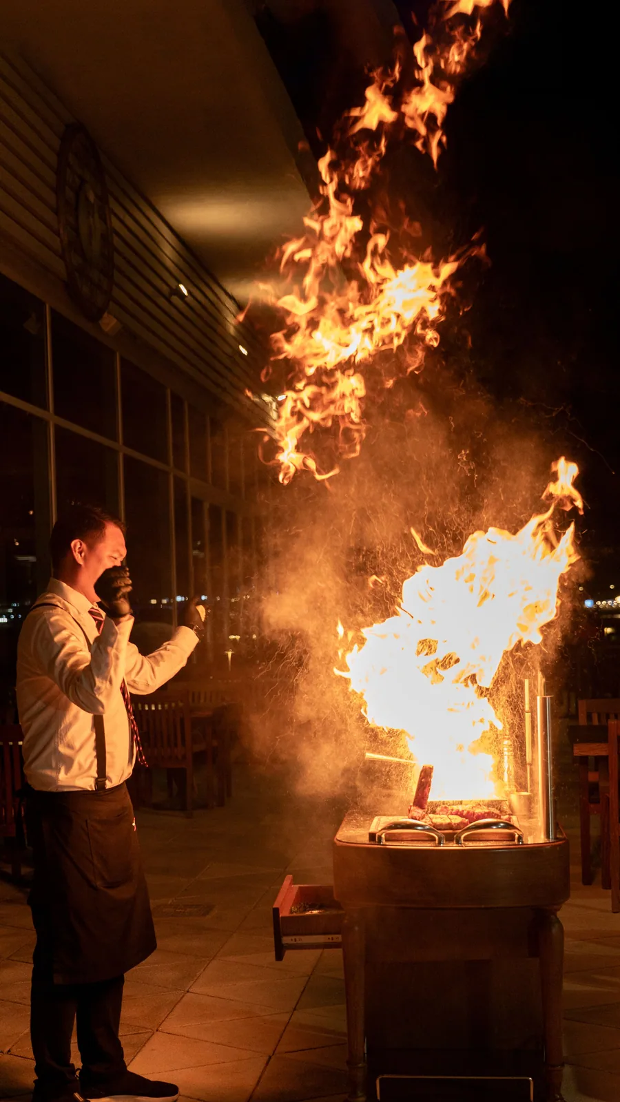 A dramatic burst of fire from a teppanyaki grill during an evening performance